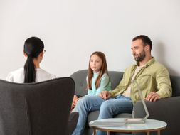 padre e hija sentadas en la consulta con la psicóloga